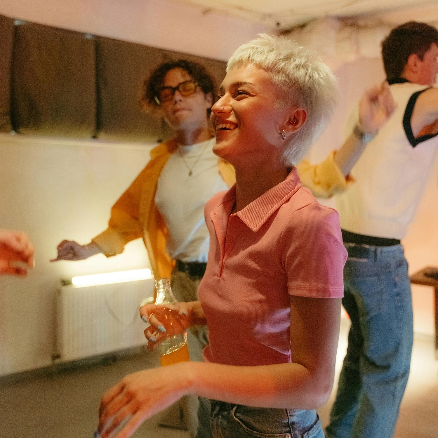 Woman in a pink shirt smiling with people in the background